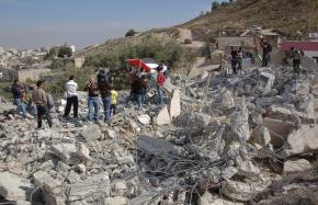 A Palestinian family stands in the wreckage of their East Jerusalem home, bulldozed by Israeli forces