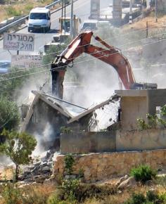 An Israeli bulldozer demolishing a West Bank home
