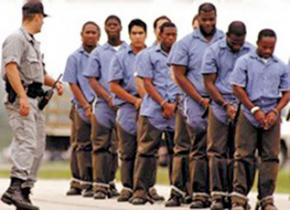 Shackled prisoners are led outside to begin a day of labor