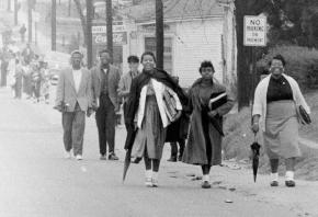 Boycotters walk along the side of a Montgomery street