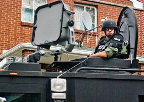 Philadelphia police ride in an armored vehicle down a residential street