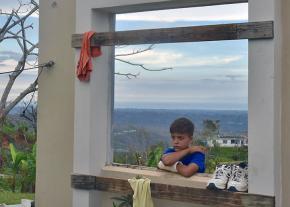 A child stands in the ruins of his house in Utuado, Puerto Rico