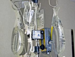 Saline bags manufactured by the medical corporation Baxter hang on a hospital IV stand